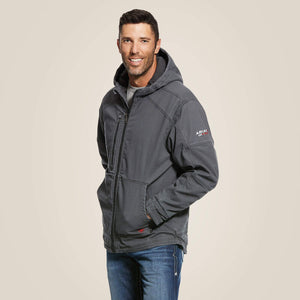 Side view of a man wearing blue Ariat stretch FR jacket