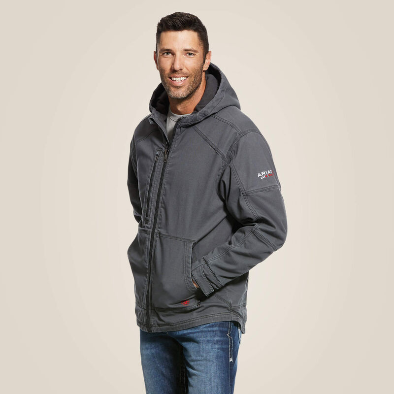 Side view of a man wearing blue Ariat stretch FR jacket