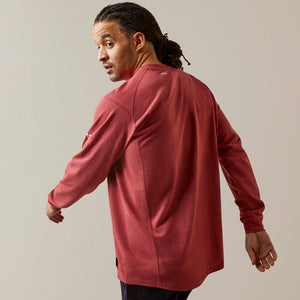 Back view of a man wearing brick Ariat FR Henley Shirt
