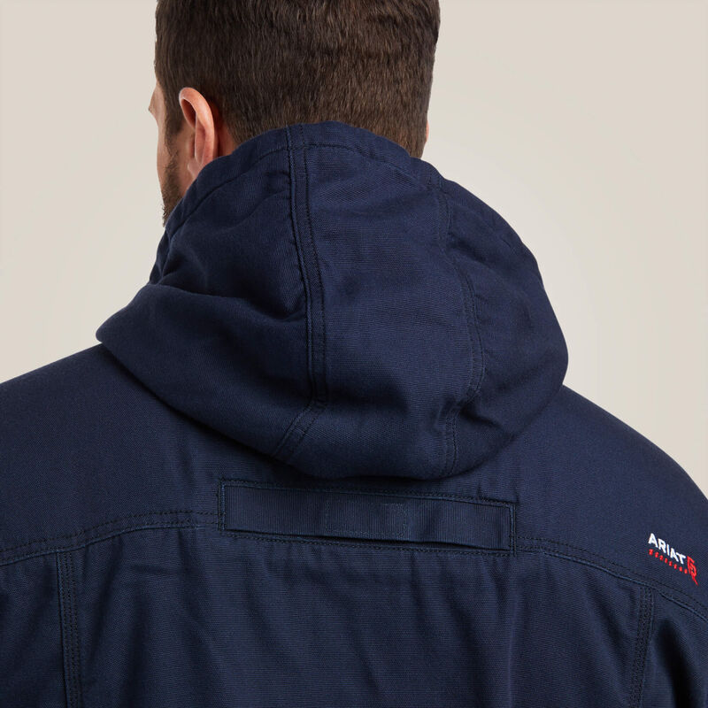 A man wearing blue Ariat stretch FR jacket zoomed in from the back