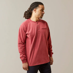 Front view of a man wearing brick Ariat FR Henley Shirt
